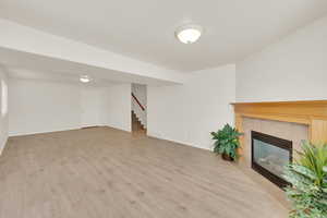 Another view of basement family room with gas fireplace and new vinyl flooring.