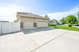 Large RV parking with gates on vinyl fence on both sides of home. Completely fenced yard with vinyl fencing.