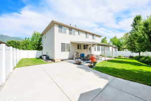 The backyard features an extended large concrete patio, offering ample space for outdoor dining and entertaining.
