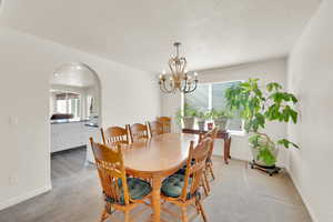 Dining room with arched walkway to kitchen area