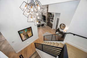 Stairway featuring a chandelier and wood finished floors