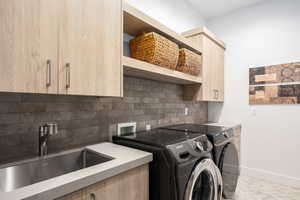 Washroom featuring cabinet space and separate washer and dryer