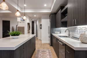 Kitchen featuring dark brown cabinetry, light wood-style flooring, light countertops, and recessed lighting