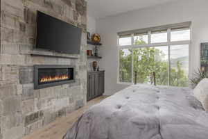 Bedroom featuring light wood-style flooring and a fireplace