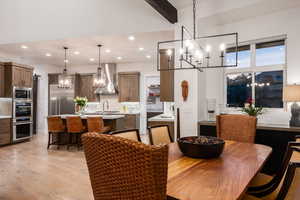 Dining area with a chandelier, light wood-type flooring, beam ceiling, and recessed lighting