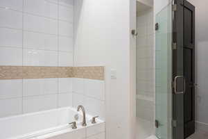 Bathroom with a shower stall and a garden tub