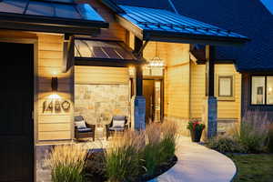 View of side of home with a standing seam roof, a metal roof, and stone siding
