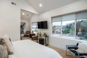 Bedroom with light colored carpet, high vaulted ceiling, and recessed lighting