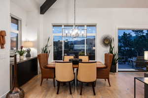Dining room featuring wood finished floors, a chandelier, beam ceiling, and plenty of natural light