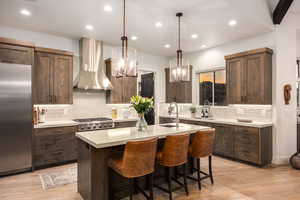 Kitchen featuring light wood finished floors, decorative backsplash, appliances with stainless steel finishes, light countertops, and recessed lighting