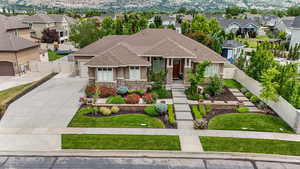 View of front of property with a gate, stone siding, driveway, stucco siding, and a residential view