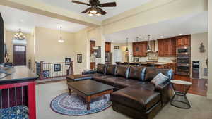 Living area with ceiling fan, recessed lighting, wood finished floors, and a chandelier