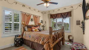 Bedroom featuring carpet, baseboards, and ceiling fan