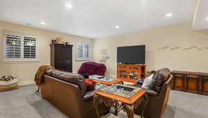 Carpeted living room with recessed lighting and baseboards