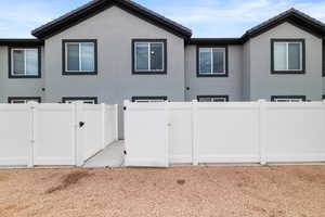 View of property exterior featuring a gate, stucco siding, and a tiled roof