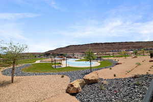Surrounding community with a mountain view, a lawn, and a pool