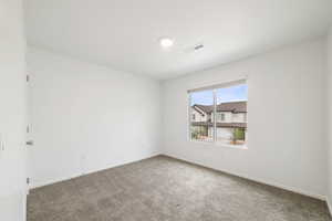 Carpeted spare room with baseboards