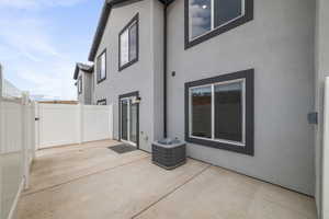 Rear view of house featuring a patio area, stucco siding, and central AC