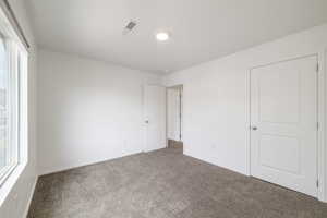 Unfurnished bedroom featuring carpet flooring, baseboards, and recessed lighting