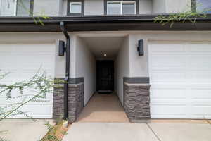 Property entrance featuring stucco siding and stone siding