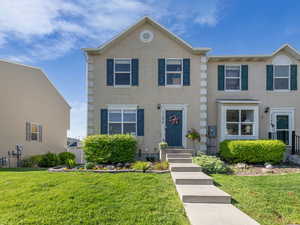 View of front of home with a front yard and stucco siding