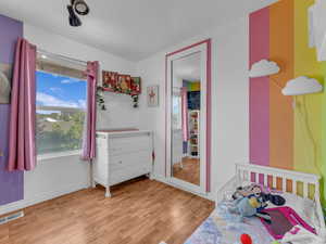 Bedroom featuring wood finished floors and baseboards