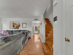 Living area with light wood-type flooring and stairway
