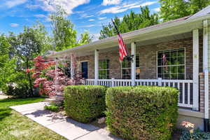 View of front of property with covered porch and brick siding