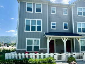 View of front of home featuring covered porch, board and batten siding, and a fenced front yard