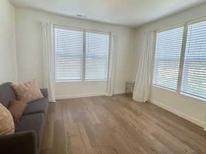 Living room featuring dark wood-style floors, plenty of natural light, and baseboards