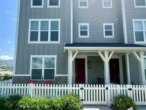 View of front of property featuring board and batten siding, a porch, and a fenced front yard