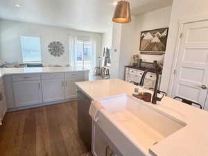 Kitchen with dishwasher, dark wood-style floors, decorative light fixtures, a sink, and recessed lighting