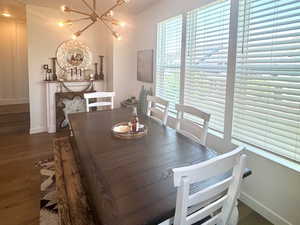Dining room with a chandelier, wood finished floors, baseboards, and lofted ceiling