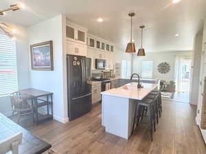 Kitchen featuring black appliances, light wood finished floors, a sink, plenty of natural light, and recessed lighting