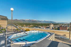 View of pool featuring a mountain view and an outdoor hot tub