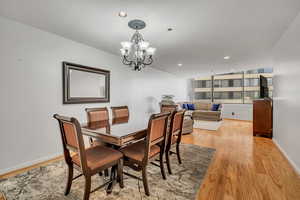 Dining room featuring light wood-type flooring, a chandelier, recessed lighting, and baseboards