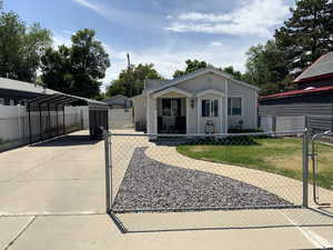 View of front facade featuring a carport, a gate, and driveway