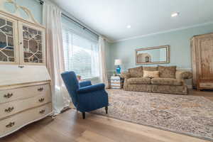 Living room featuring crown molding, wood finished floors, and recessed lighting
