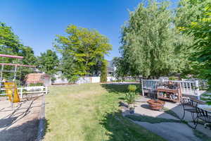 View of yard with an outdoor fire pit, a patio area, and a playground
