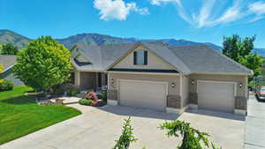 Craftsman-style home featuring driveway, brick siding, and a mountain view