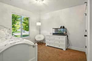 Bedroom with light colored carpet and baseboards