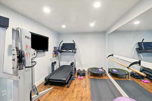 Workout room with wood finished floors, recessed lighting, and baseboards