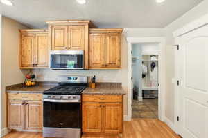 Kitchen featuring appliances with stainless steel finishes, light wood-style flooring, and baseboards