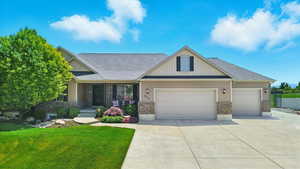 Craftsman house with an attached garage, brick siding, a front lawn, and concrete driveway