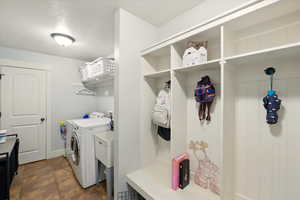 Washroom featuring independent washer and dryer and baseboards
