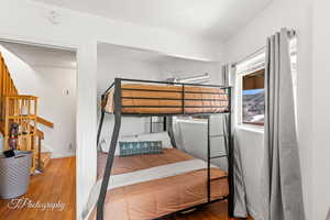 Bedroom with wood finished floors and baseboards