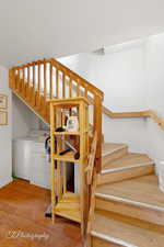 Staircase featuring washer and dryer, wood finished floors, a textured ceiling, and baseboards