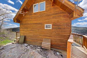View of side of home featuring a wooden deck