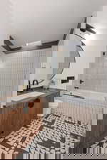 Full bathroom with toilet, tile patterned floors, vanity, and tiled shower / bath