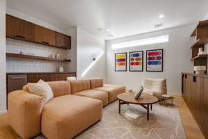 Living room with light wood finished floors, recessed lighting, and baseboards